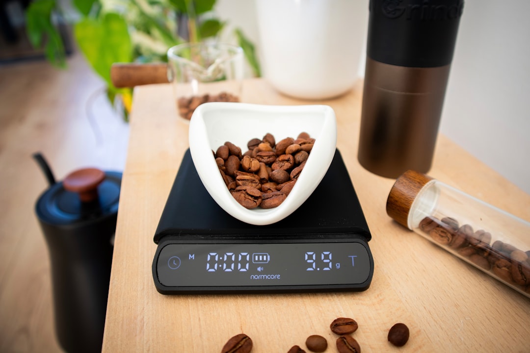 A barista recording espresso shot data on a notebook while pulling a 12-shot protocol for dialing in a new bean