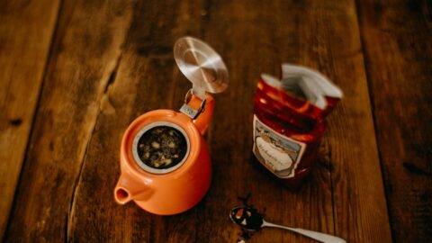 Close-up of loose leaf tea brewing with a temperature-controlled kettle and a scale measuring two grams of leaves