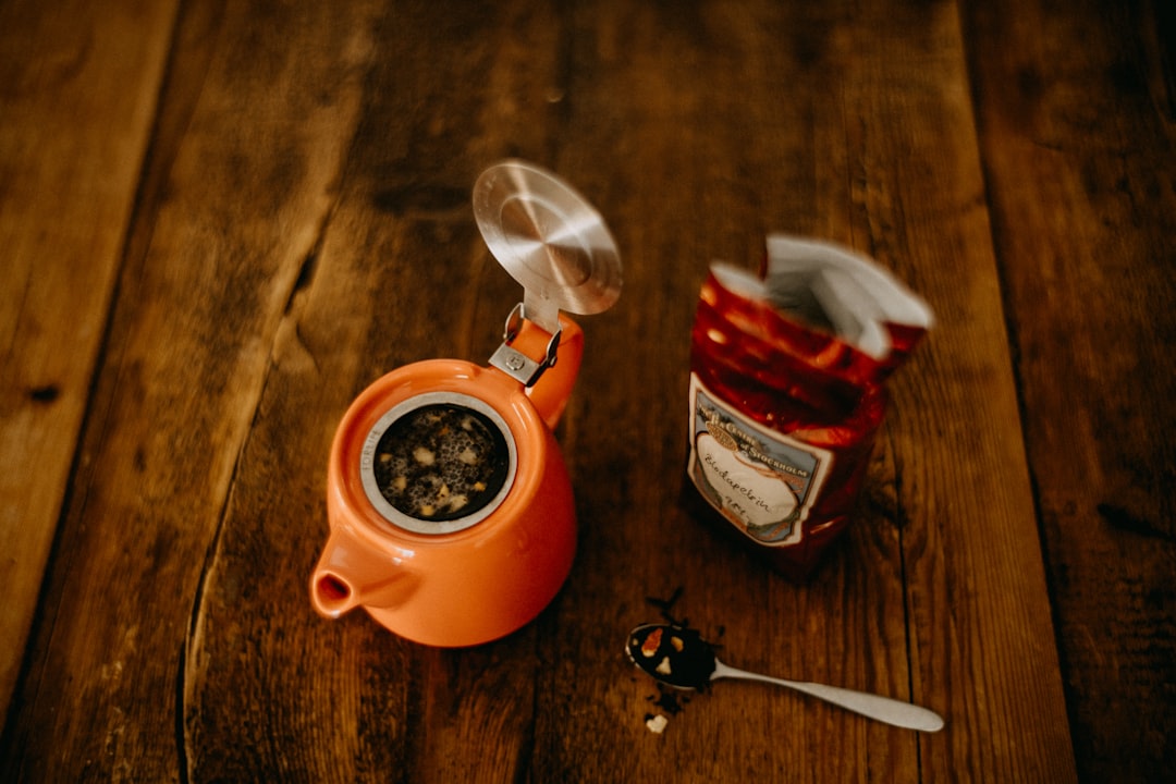 Close-up of loose leaf tea brewing with a temperature-controlled kettle and a scale measuring two grams of leaves