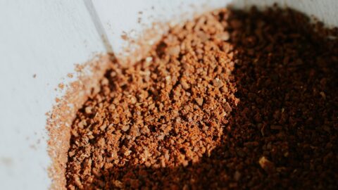 Close-up of a burr grinder producing a bimodal particle distribution for pour over coffee, showing distinct fines and boulders