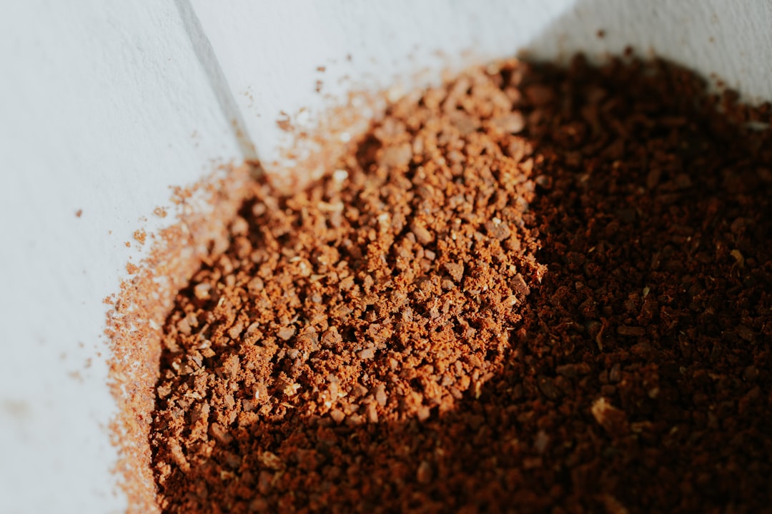 Close-up of a burr grinder producing a bimodal particle distribution for pour over coffee, showing distinct fines and boulders