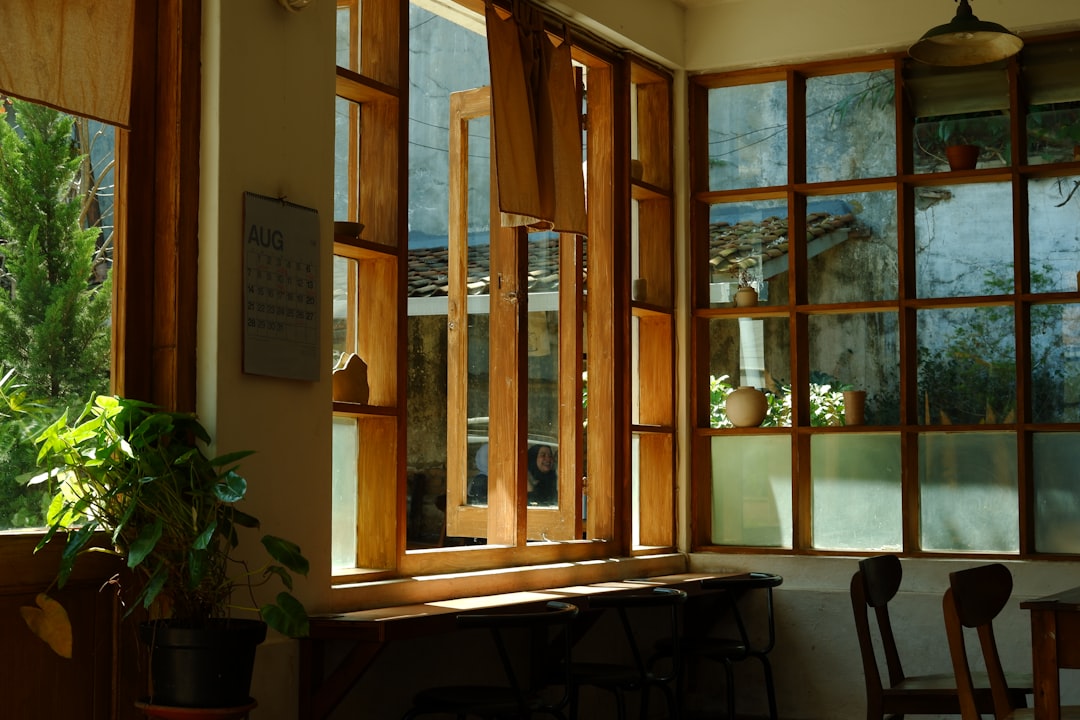 A quiet Japanese kissatten cafe interior with a barista pouring coffee slowly into a glass cup, focusing on the brewing process.