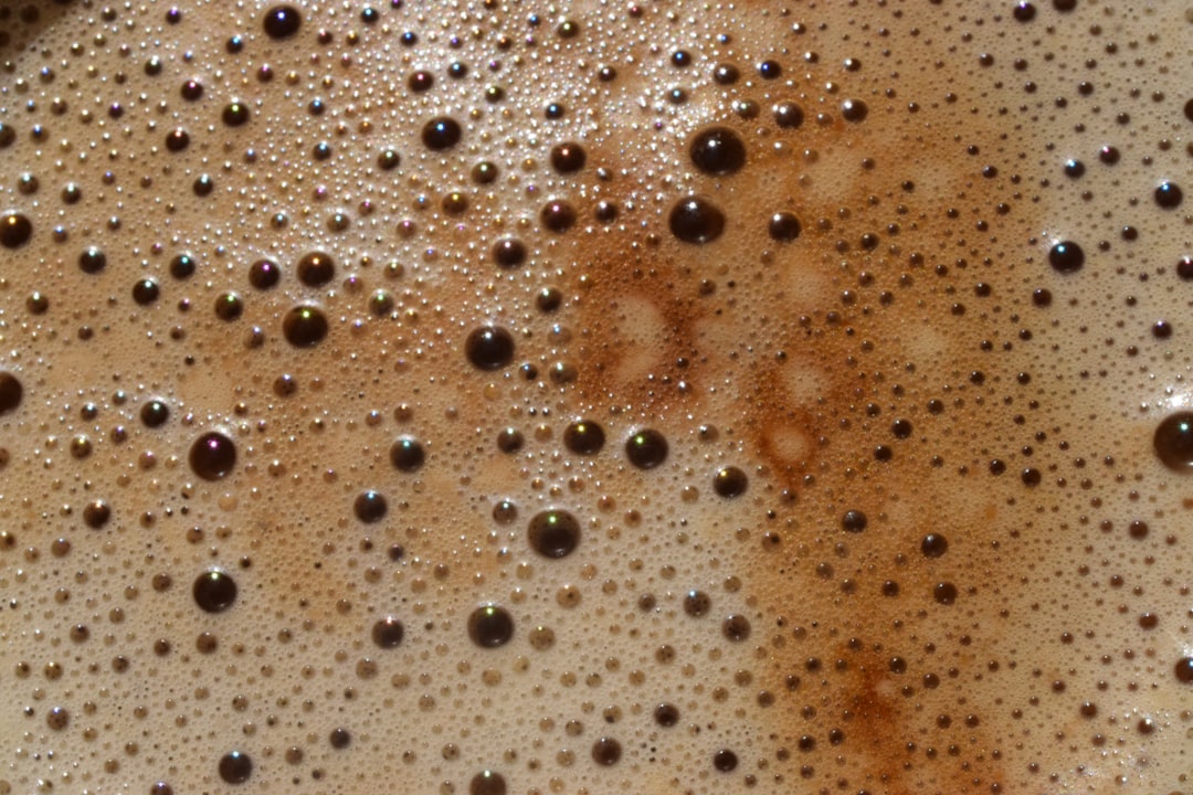 A close-up of a pour-over coffee bed showing fine coffee particles and sediment in the cup